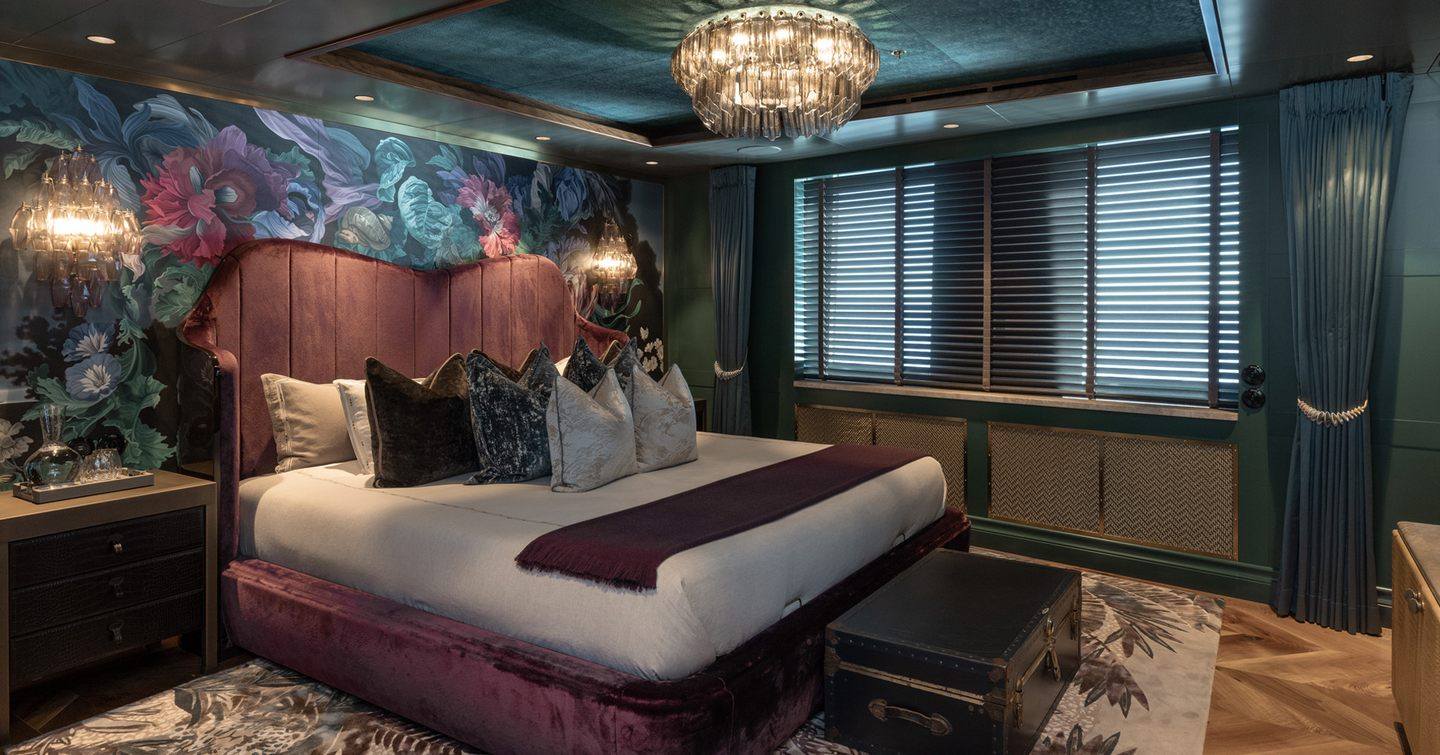 Superyacht Pink Shadow master cabin with purple headboard and avant-garde wall paper 