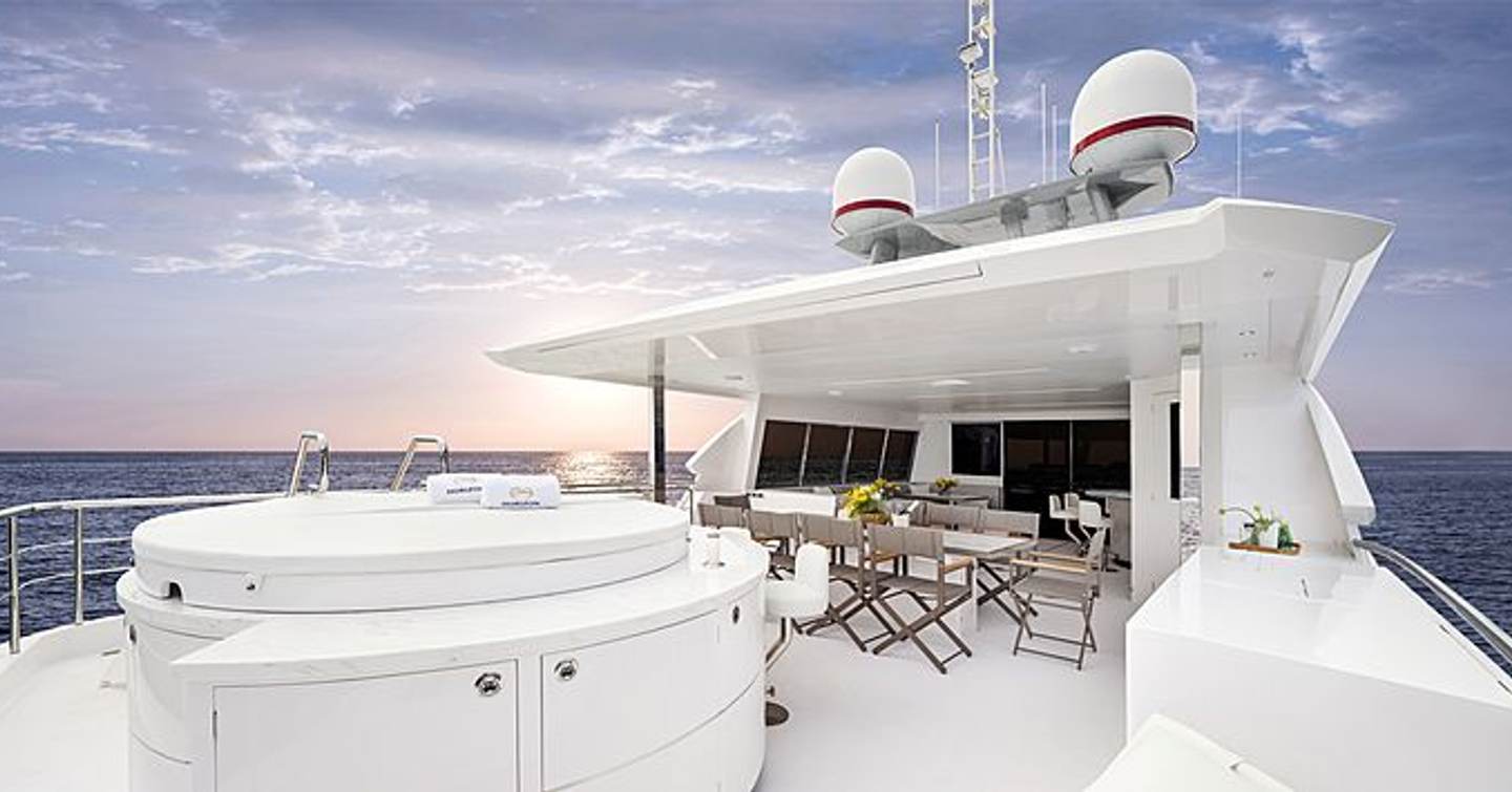 Horizon TO-KALON sun deck, with large Jacuzzi in foreground and al fresco dining table in background, surrounded by sea