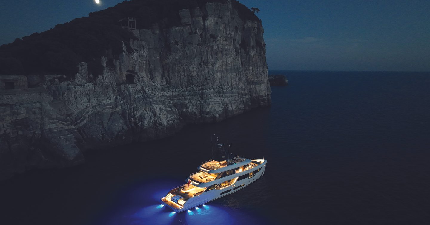Benetti Oasis 34M at anchor at night, illuminated decks and Oasis Deck lighting highlighting the yacht's exterior design.