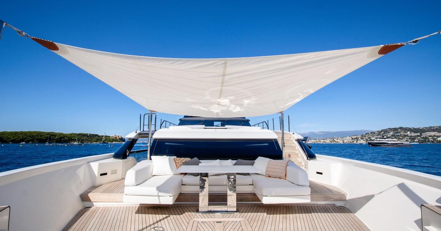 Motor yacht Le Gypsy foredeck with U-shaped white seating and canopy 