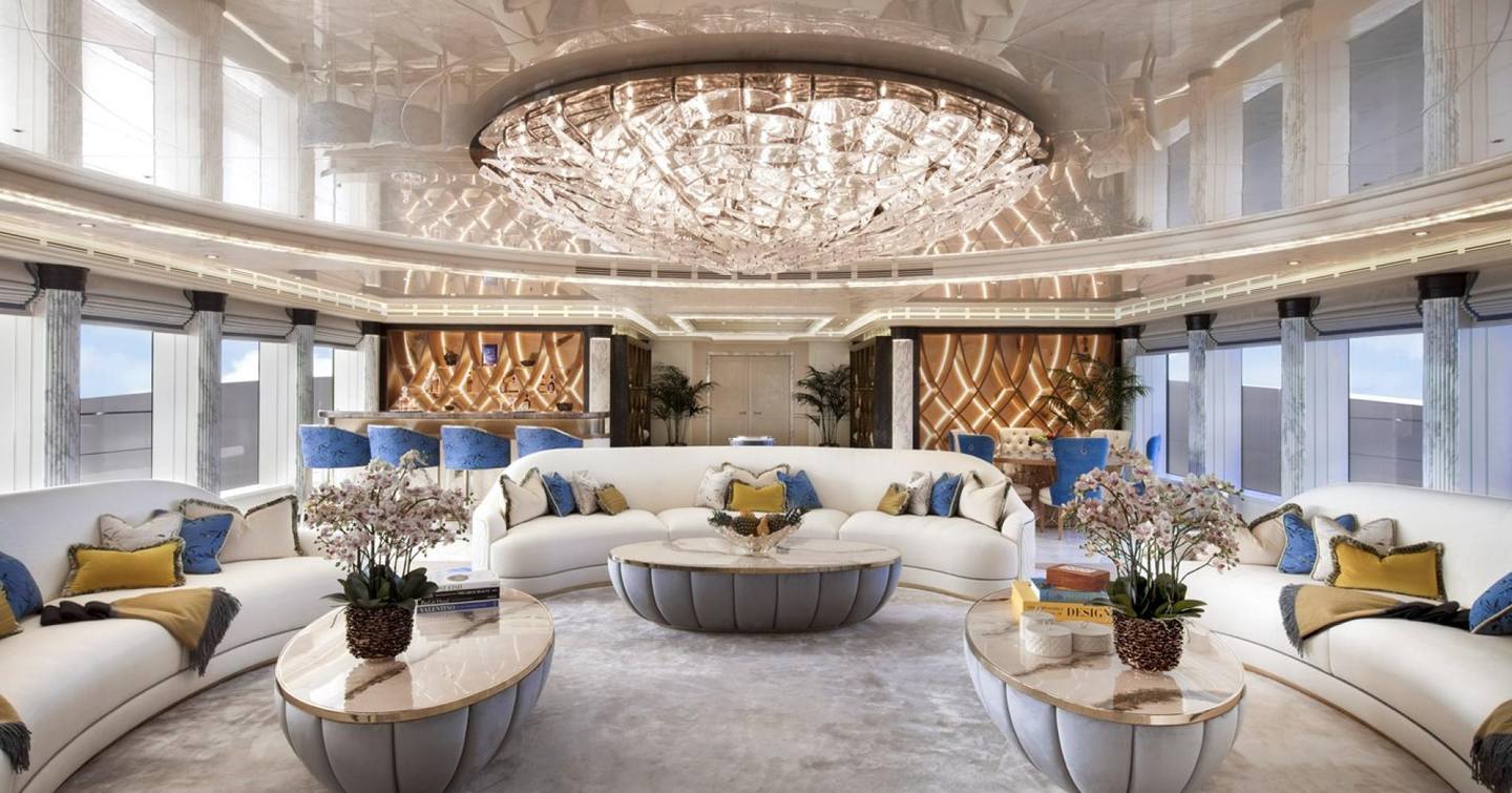Superyacht Ahpo saloon with curved white sofas and bar area with blue stools