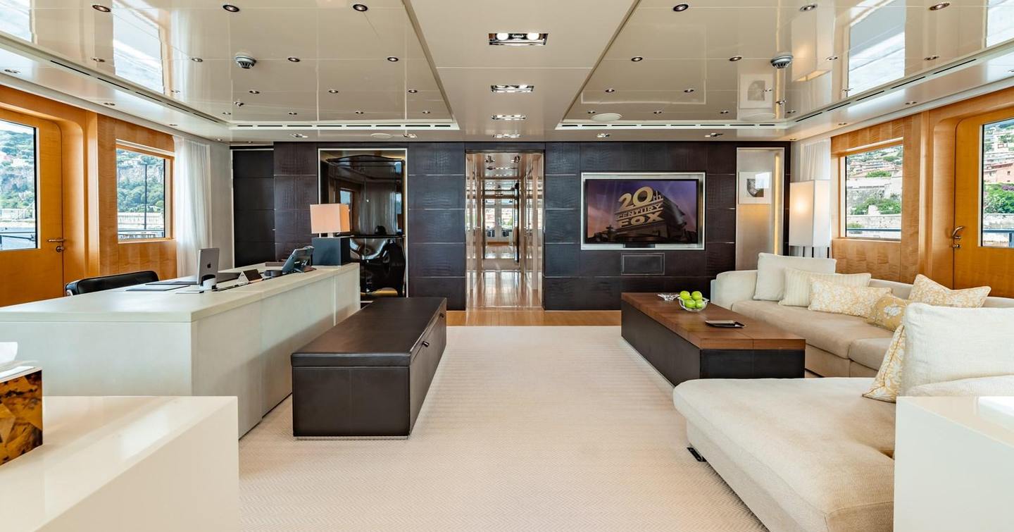 Upper saloon on motor yacht Loon, with television, desk area and L-shaped sofa 