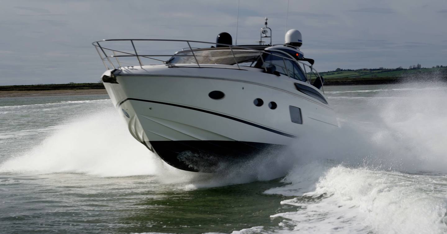 Princess V39 sports cruiser powering through the water with its bow raised and spray flying during YachtBuyer's £300,000 used boat race.