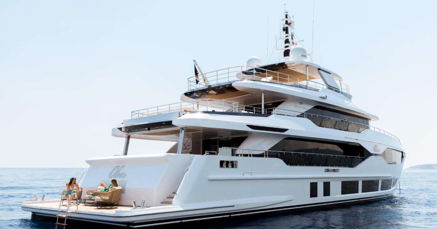 Superyacht Olivia at anchor with women lounging on the beach club