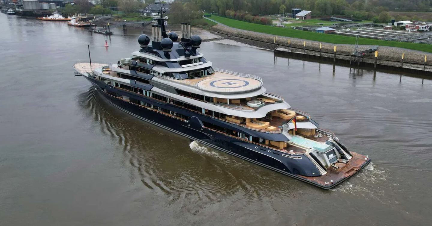 Aft view of M/Y LUMINANCE underway along German river. Green countryside on far side.