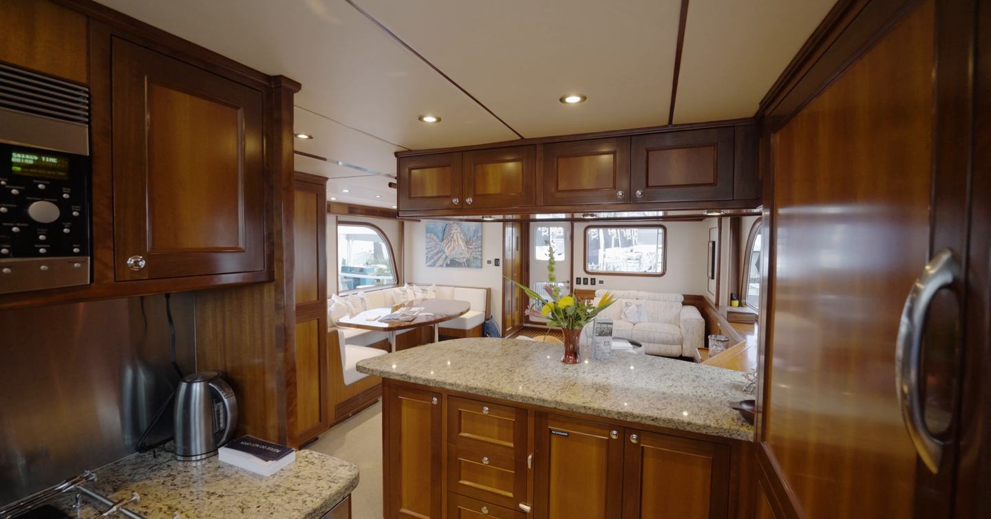 Nordhavn 75 EYF galley with granite worktops, breakfast bar and open-plan connection to the saloon