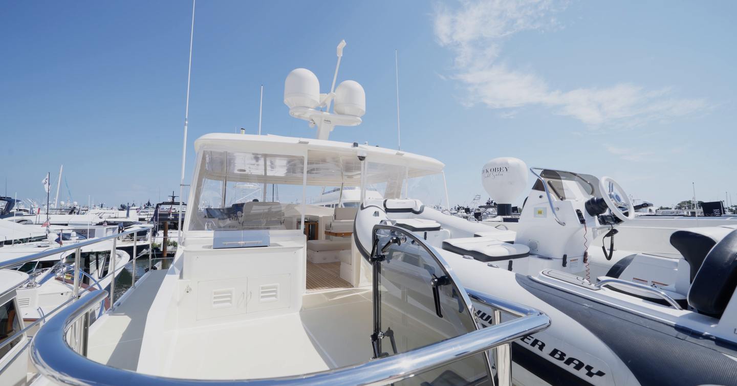 Fleming 85 boat deck with tender storage, crane access and flybridge seating area beyond