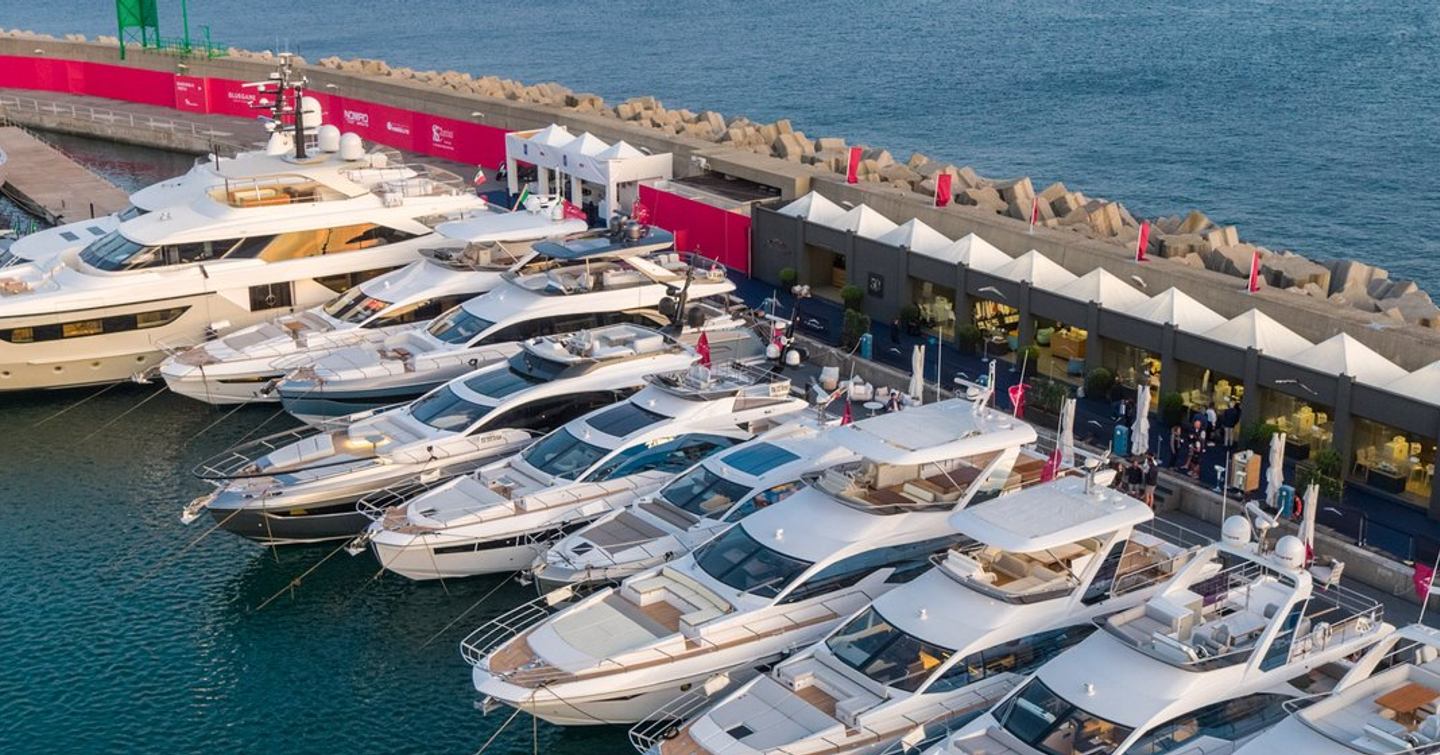 Elevated view at the exterior docks of the Genoa International Boat Show with multiple motor yachts berthed