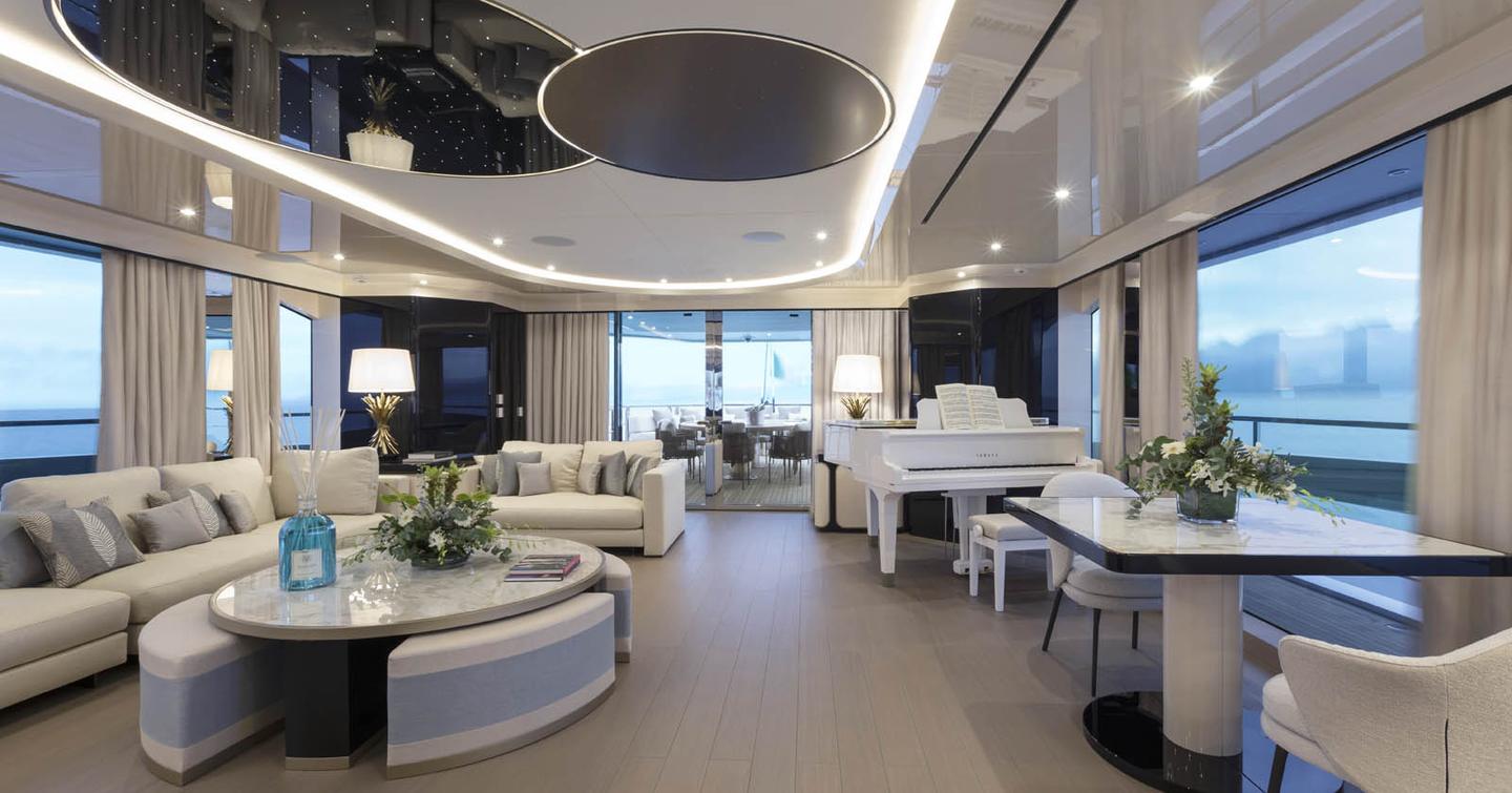 Mangusta Oceano 50 motor yacht main saloon with L-shaped sofa and grand piano