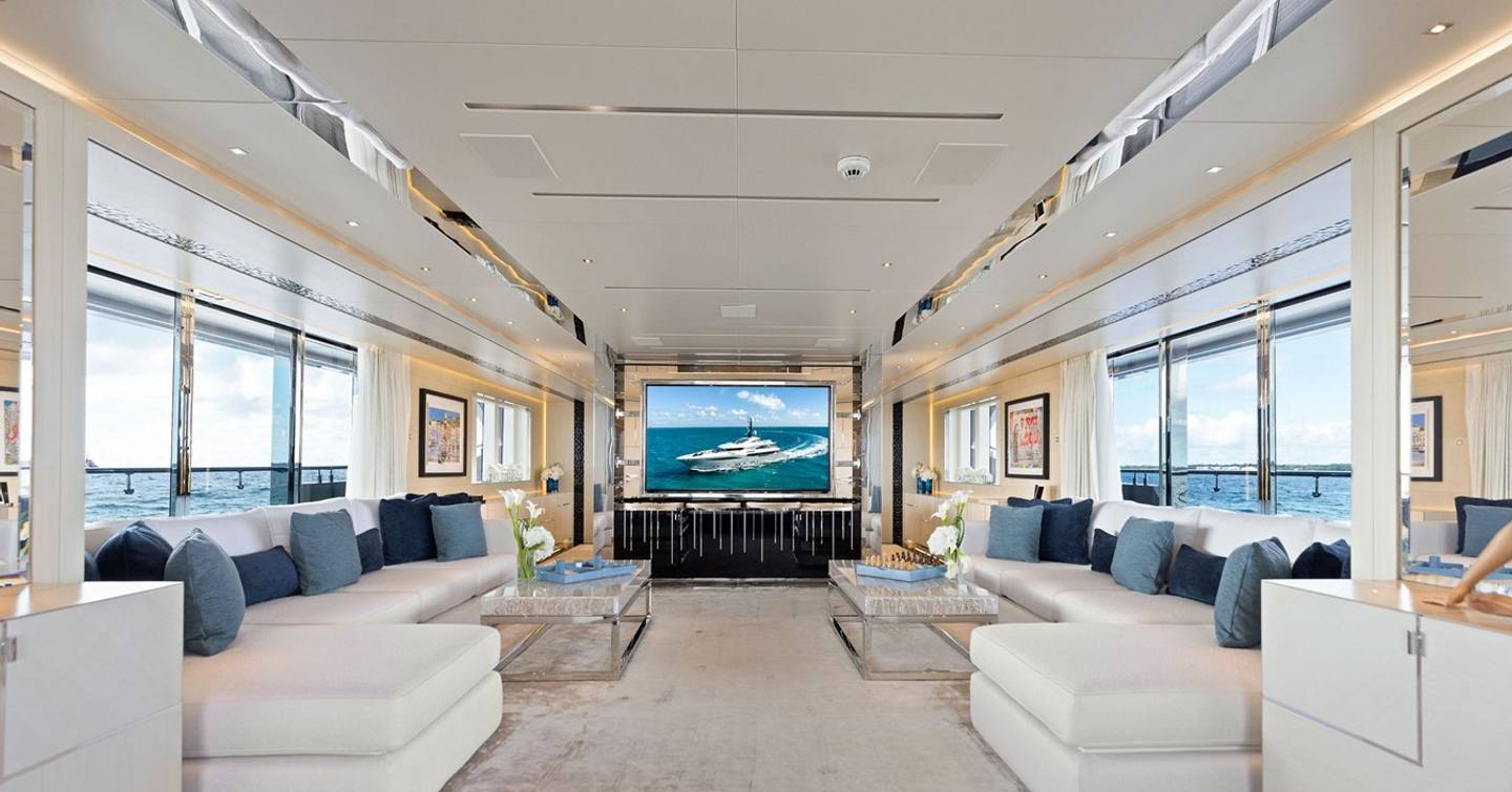 Superyacht Moonraker main saloon with L-shaped sofas and mounted TV