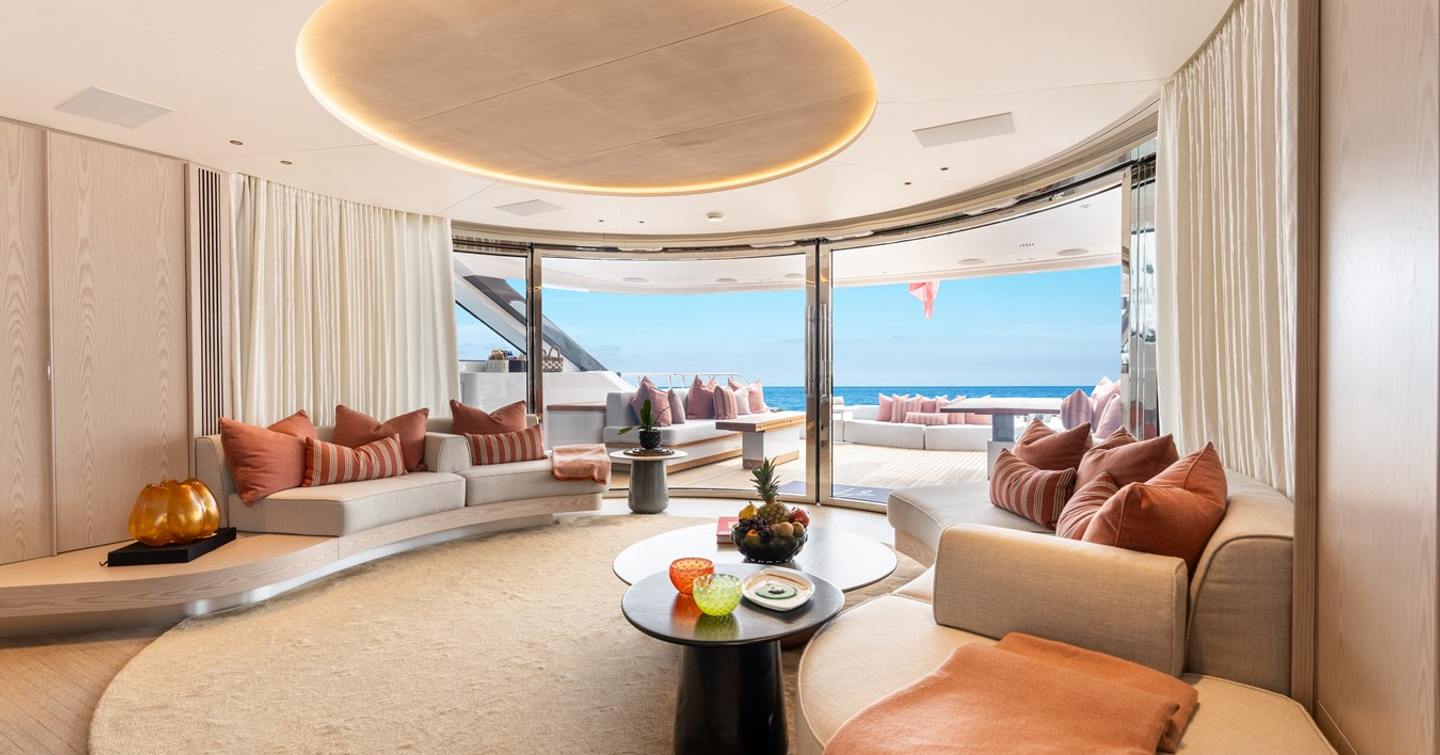 Superyacht A+'s main saloon with curved seating and neutral palette