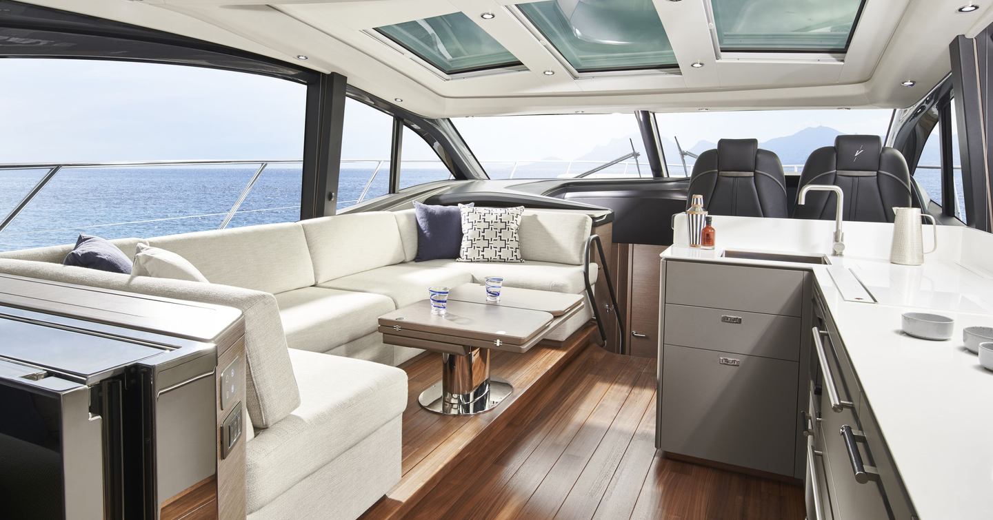 Princess V55 saloon interior showing L-shaped seating, opening sunroof and twin helm seats in 58ft hardtop sportsboat