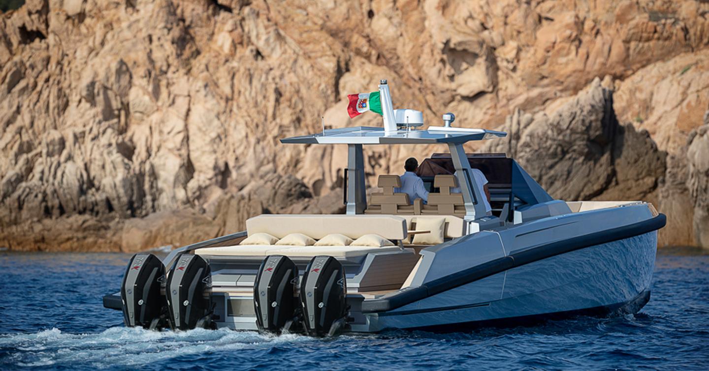 Rear view of Wally 48 Wallytender X underway, surrounded by sea and cliff face