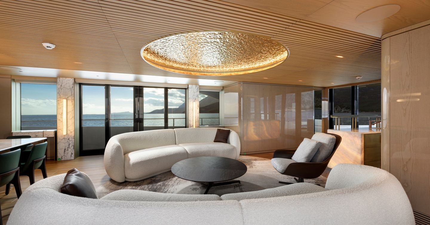 Alia Superyacht Ximena main saloon with dual curved white sofas and circular LED ceiling integrated light 