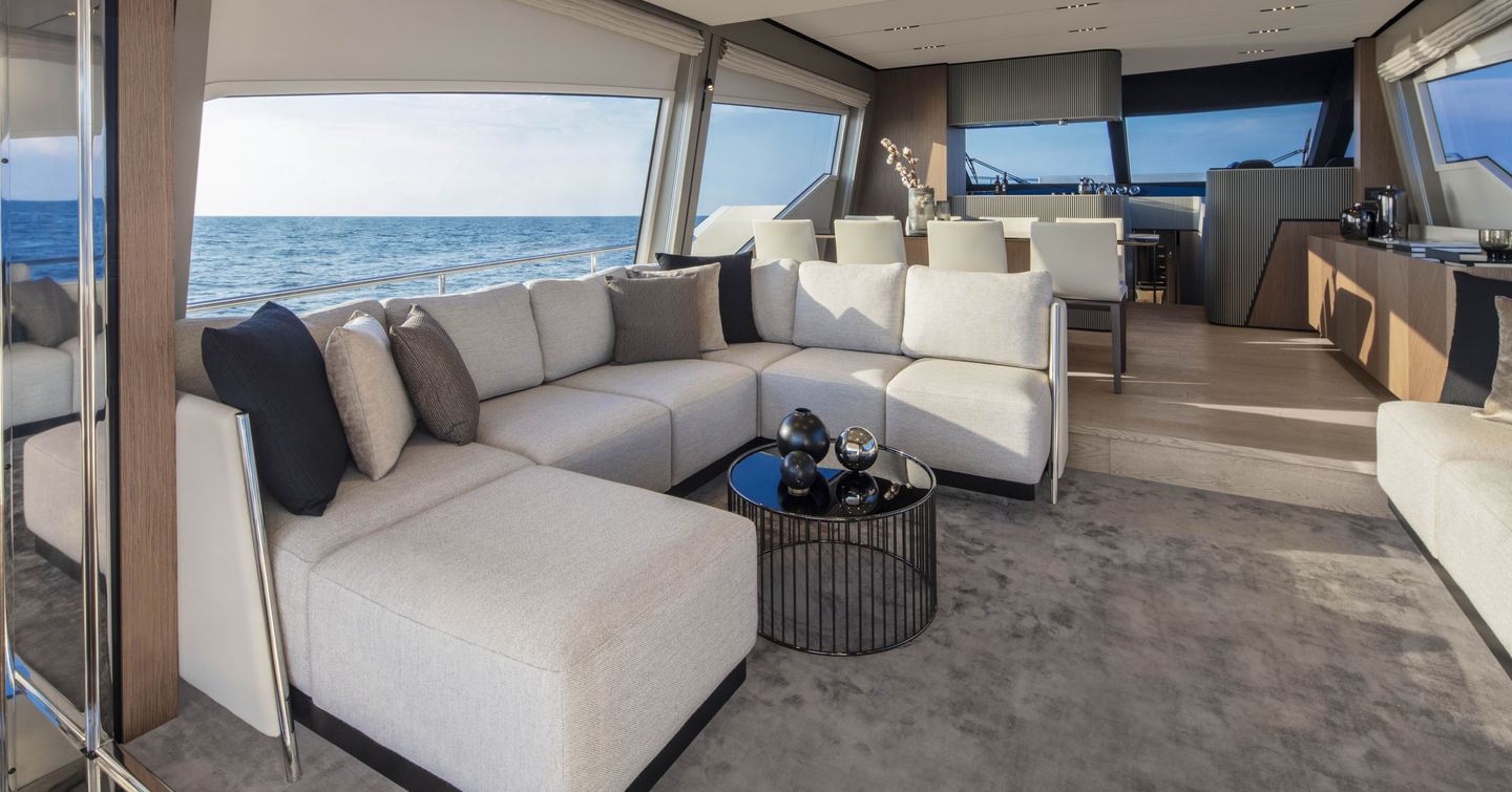Interior of second-generation Ferretti 720 main saloon with U-shaped sofa and aft dining area 