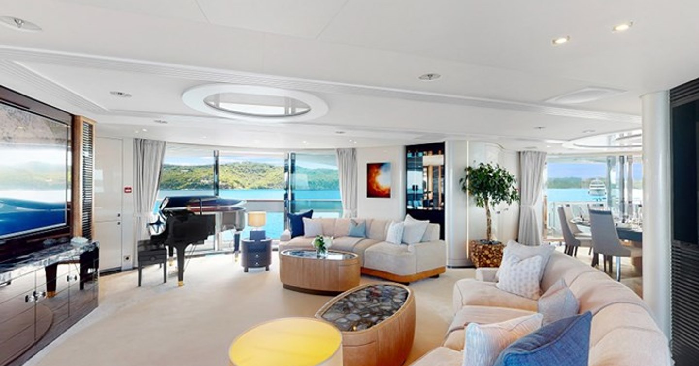 Superyacht After You's main saloon with curved seating and mounted TV