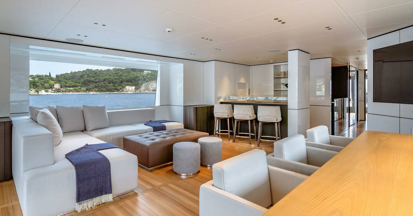 Superyacht Contigo's upper deck with L-shaped sofa and bar