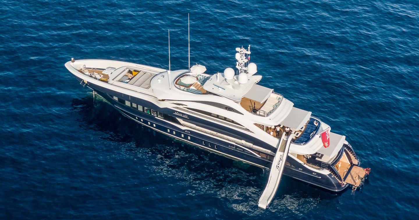 Aerial view of M/Y JULIA at sea, with water slide leading down into the sea.