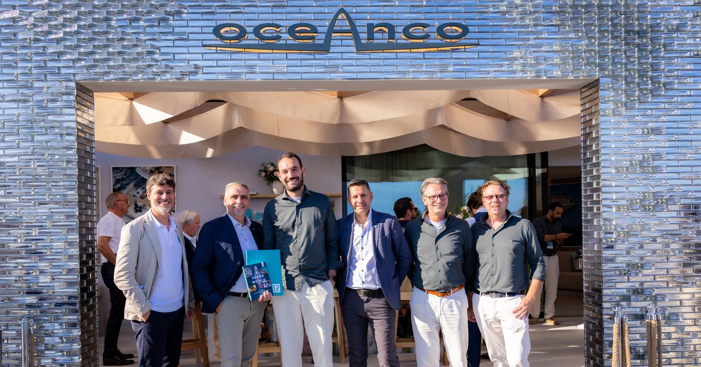 Oceanco team holding signed contract outside Oceanco stand at the Monaco Yacht Show