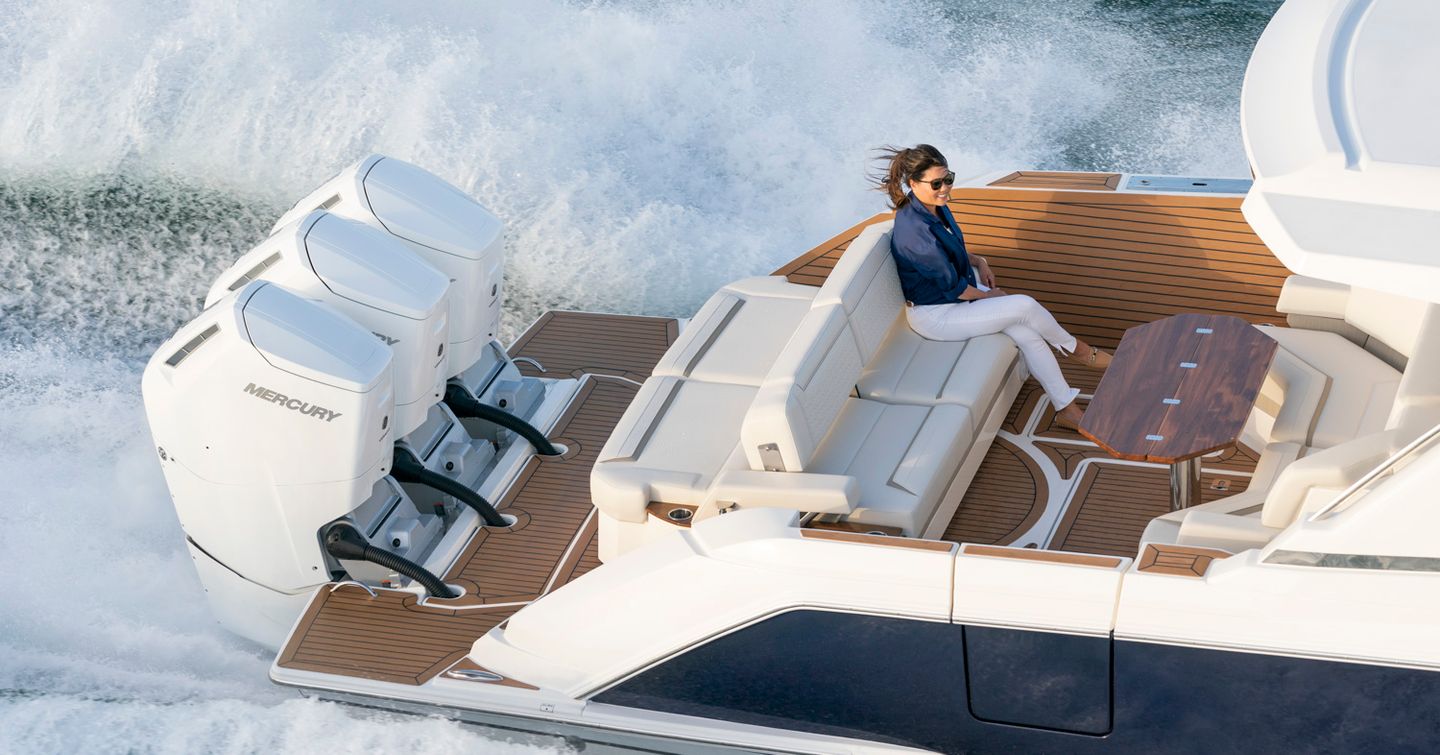 Lady on back of 48LS yacht with triple outboard motors in view