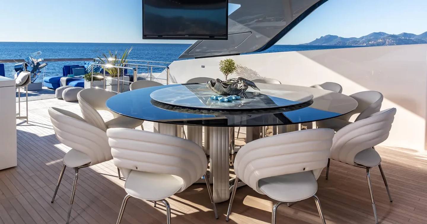 Aft deck with circular dining table and chairs on Amorcito superyacht