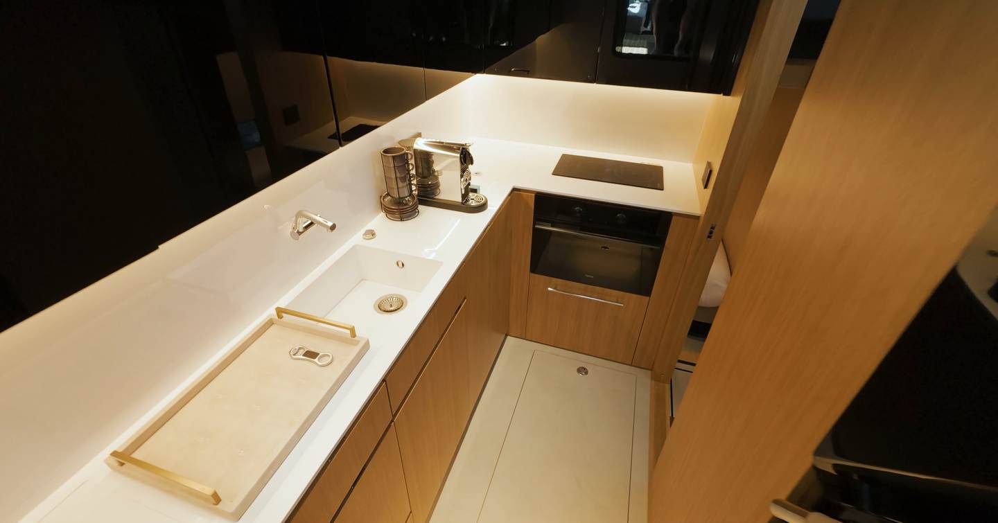 De Antonio D60 lower deck galley with minimalist layout, wood cabinetry and integrated appliances