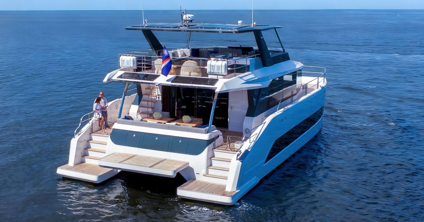 Oceanwalker S60 Catamaran at anchor with couple lounging on aft 