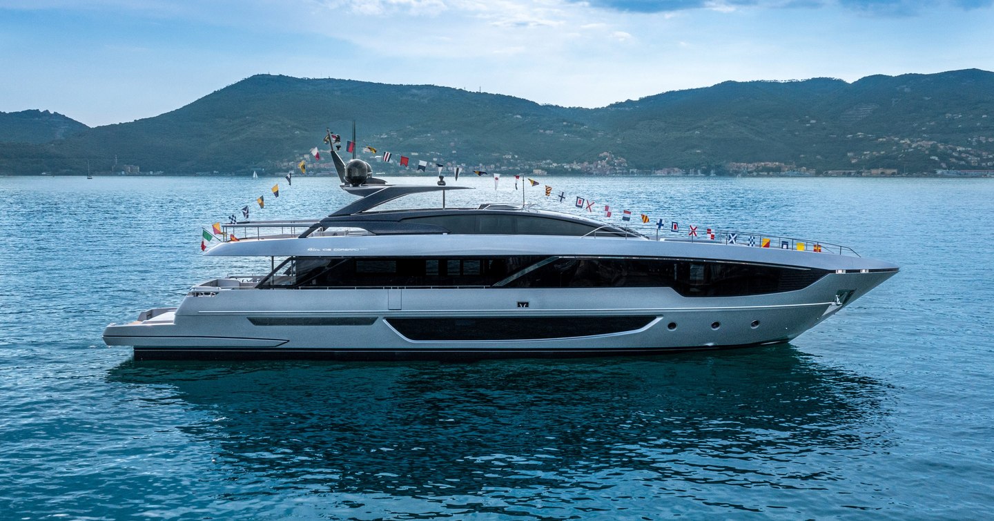 Riva 102 Corsaro Super underway, surrounded by sea and mountainous terrain in background.