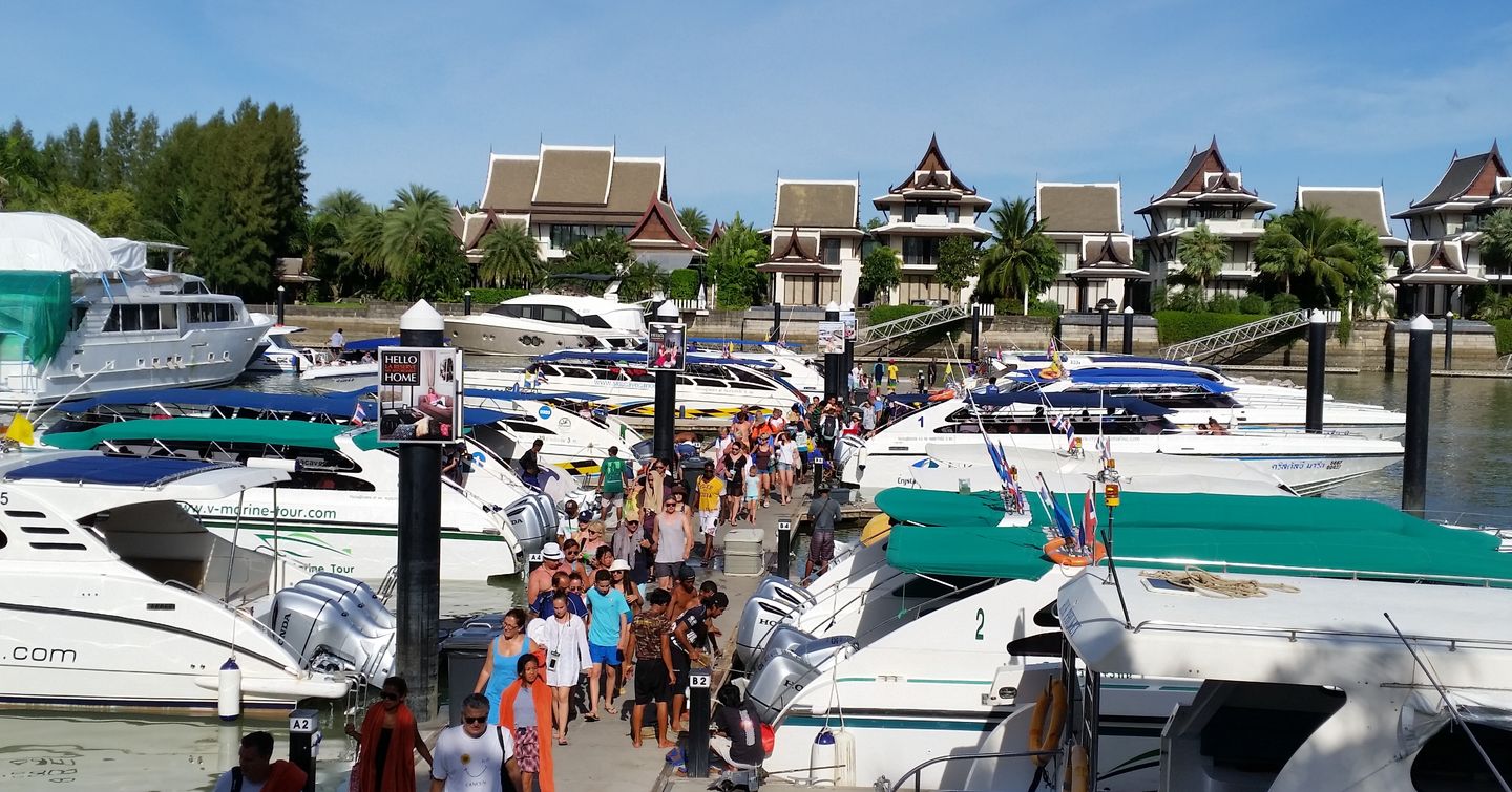 Crowds of people around yachts in docks