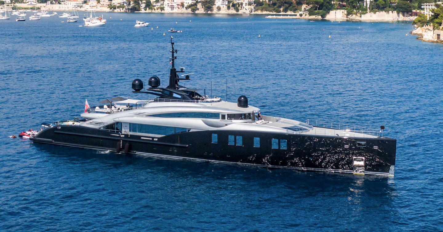 Overview of M/Y OKTO at anchor in a Mediterranean bay.