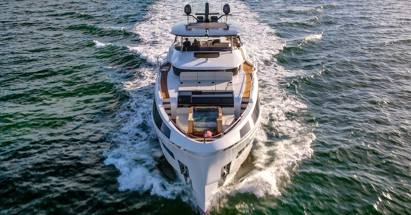 Motor Yacht Saint underway from aerial view showing full exterior profile and wake