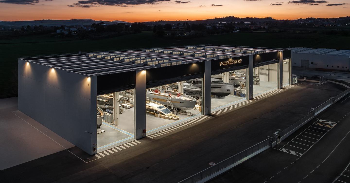 Pershing shipyard at dusk with yachts under construction