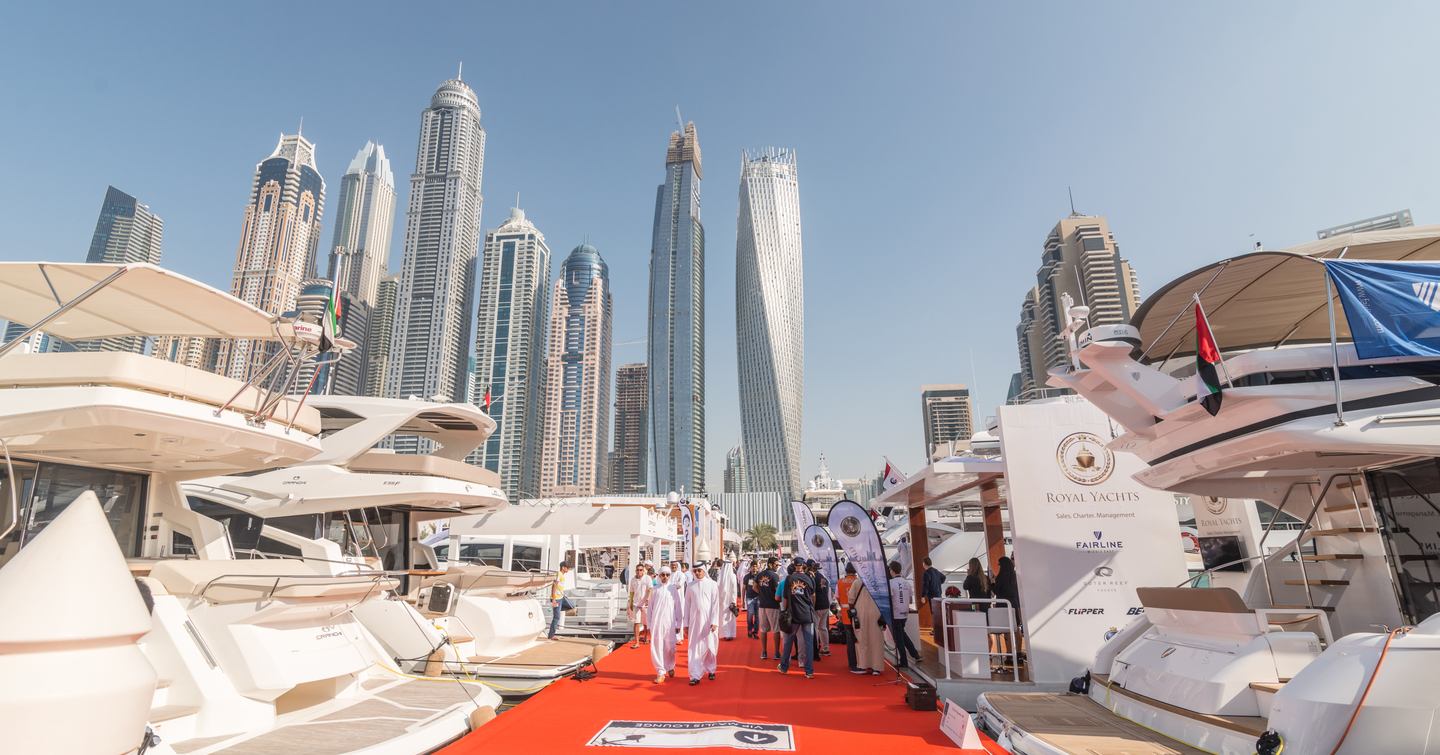 Crowds at Dubai International Boat Show with skyscrapers behind