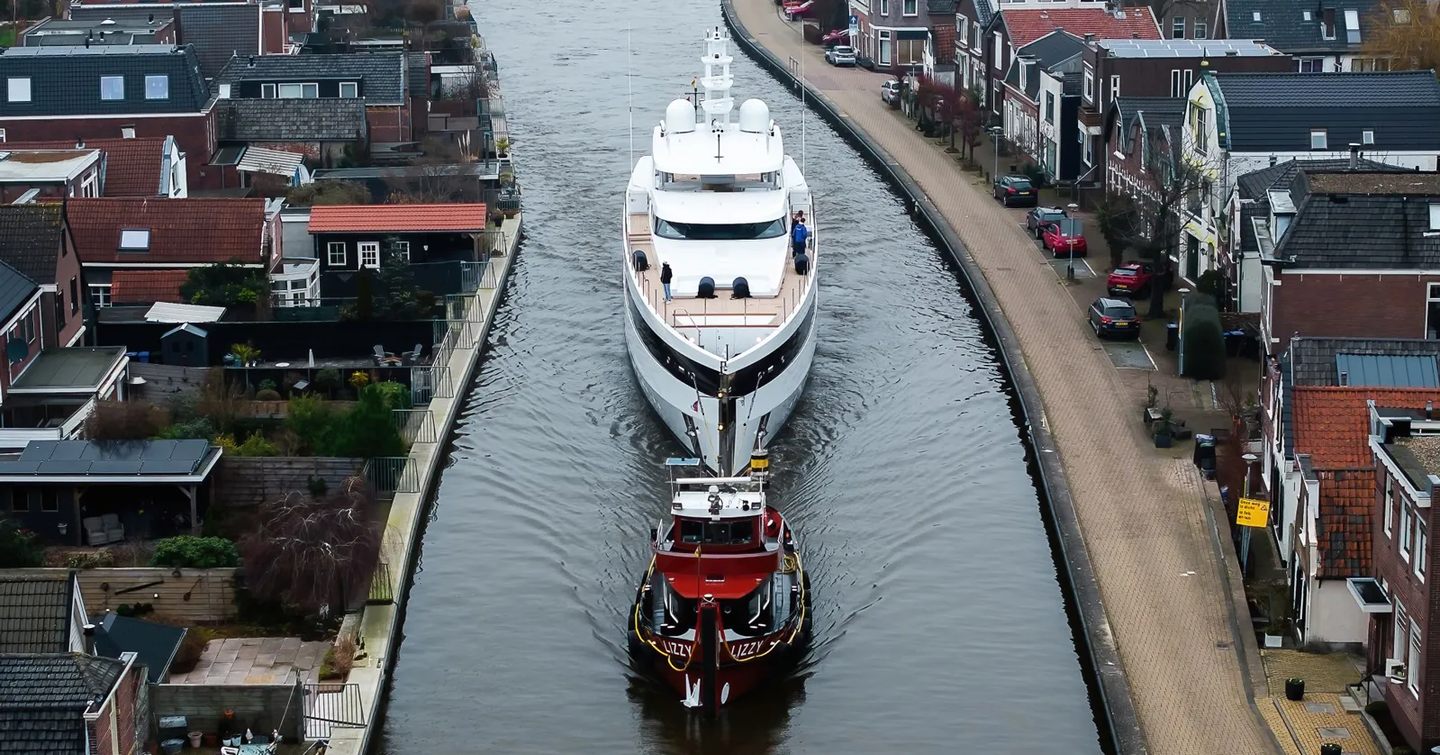 Feadship superyacht Graycliffs behind tugboat passing through dutch canals