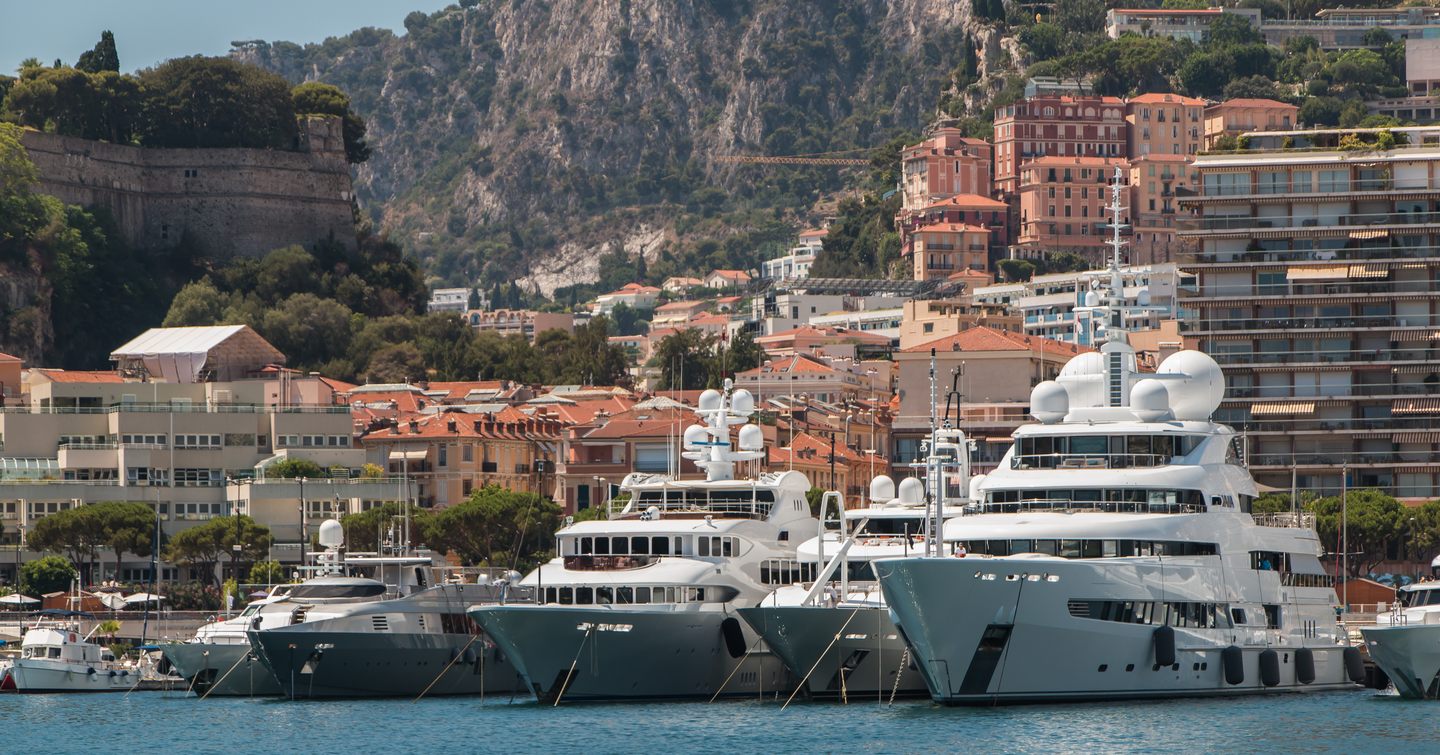 Superyachts anchored at MYS, with Monte Carlo visible in background.