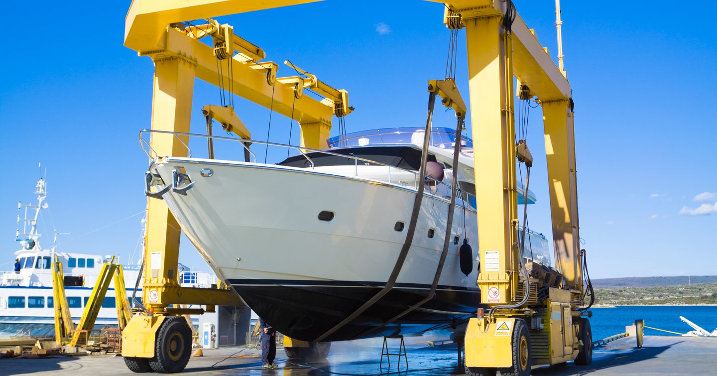 yacht being moved by a crane