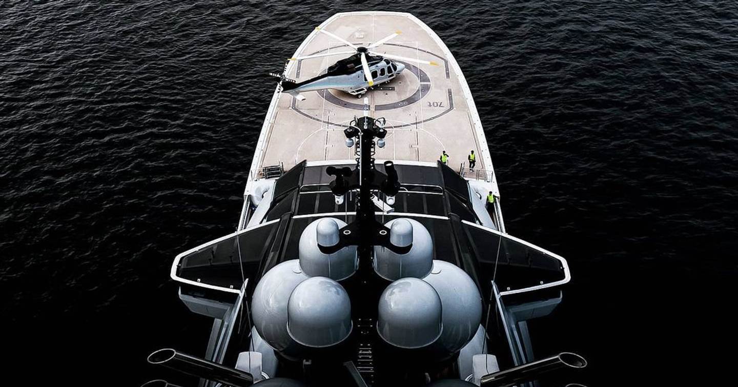 Aerial view of Superyacht Nord's bow helipad with helicopter on with black background
