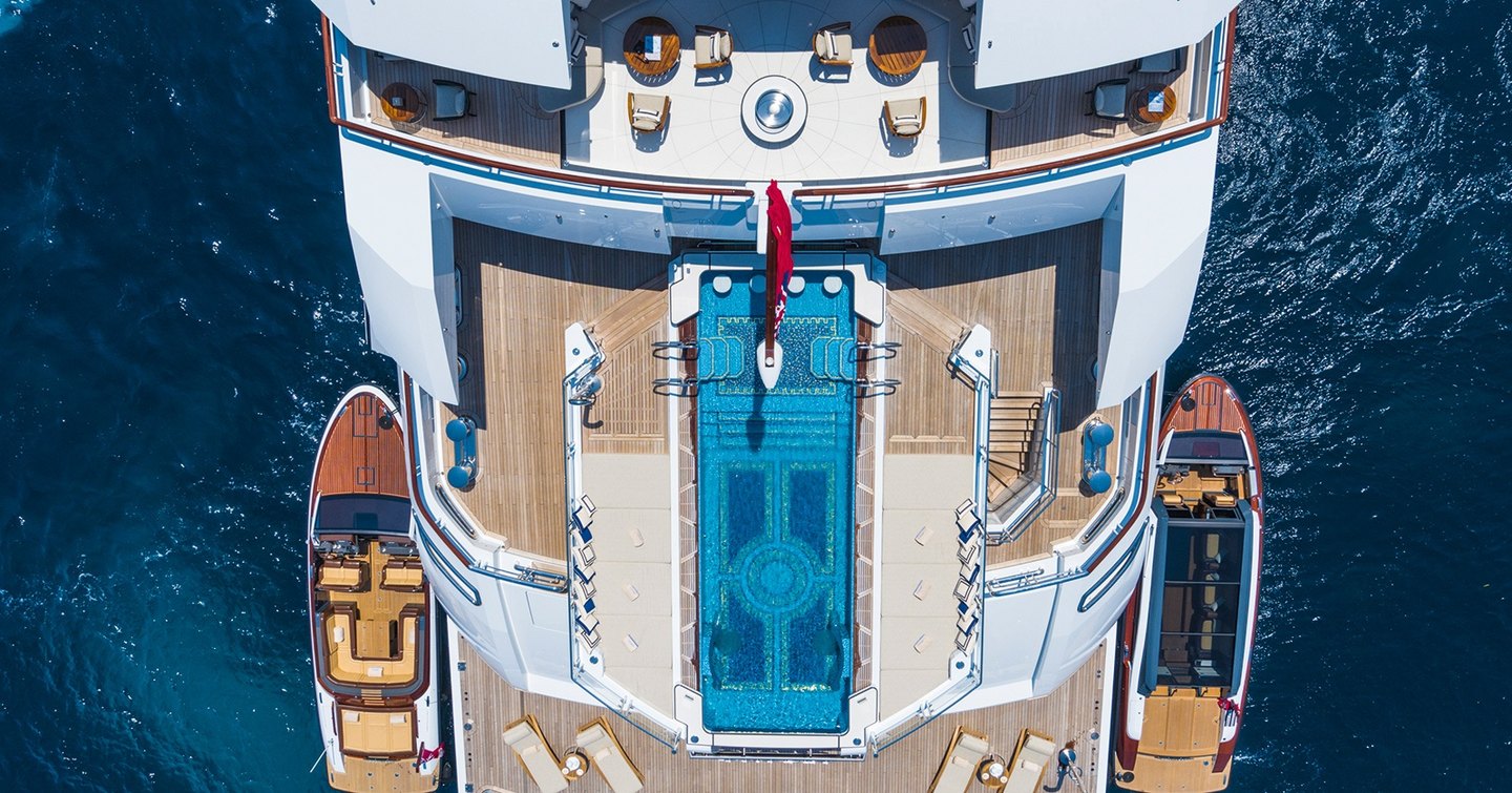 Aerial view of Superyacht Amadea beach club with dual tenders and infinity pool