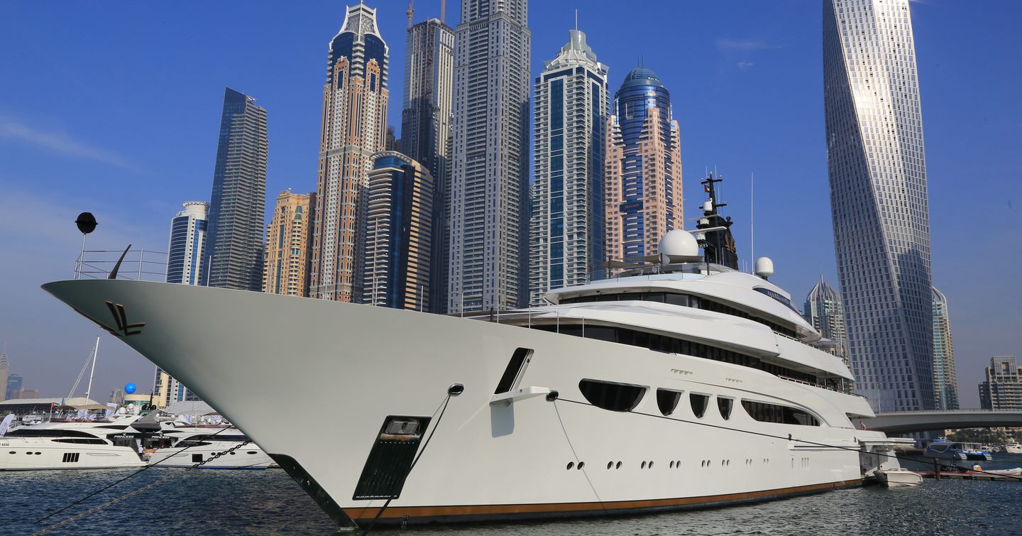 A superyacht berthed in Dubai Harbour, with the Dubai skyline in the background