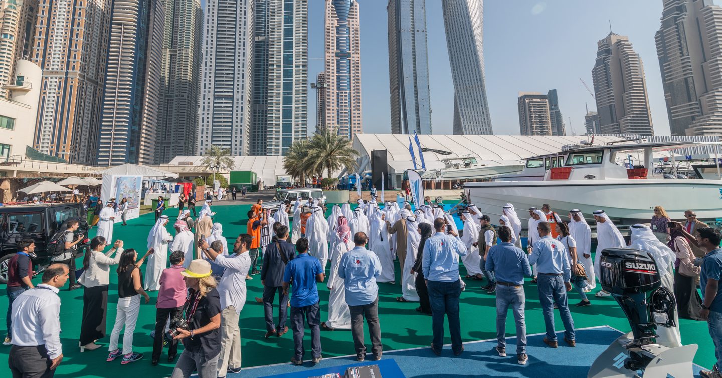 Crowds at Dubai Yacht Show with skyscrapers in background