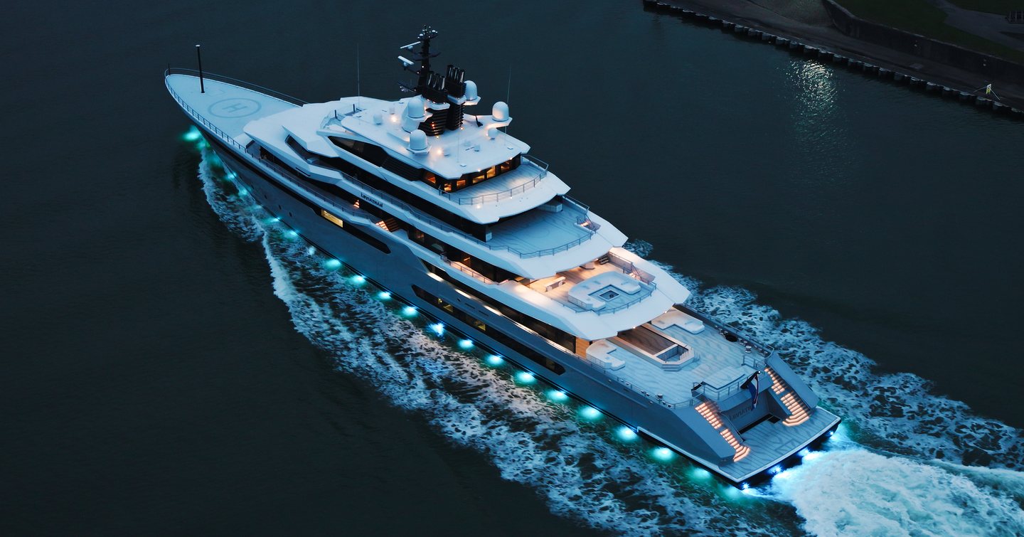 Superyacht Leviathan under way at night with underwater lights 