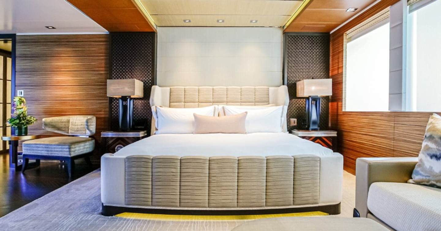 Motor yacht W's owners cabin with king sized bed, mahogany detailing and white furnishings 