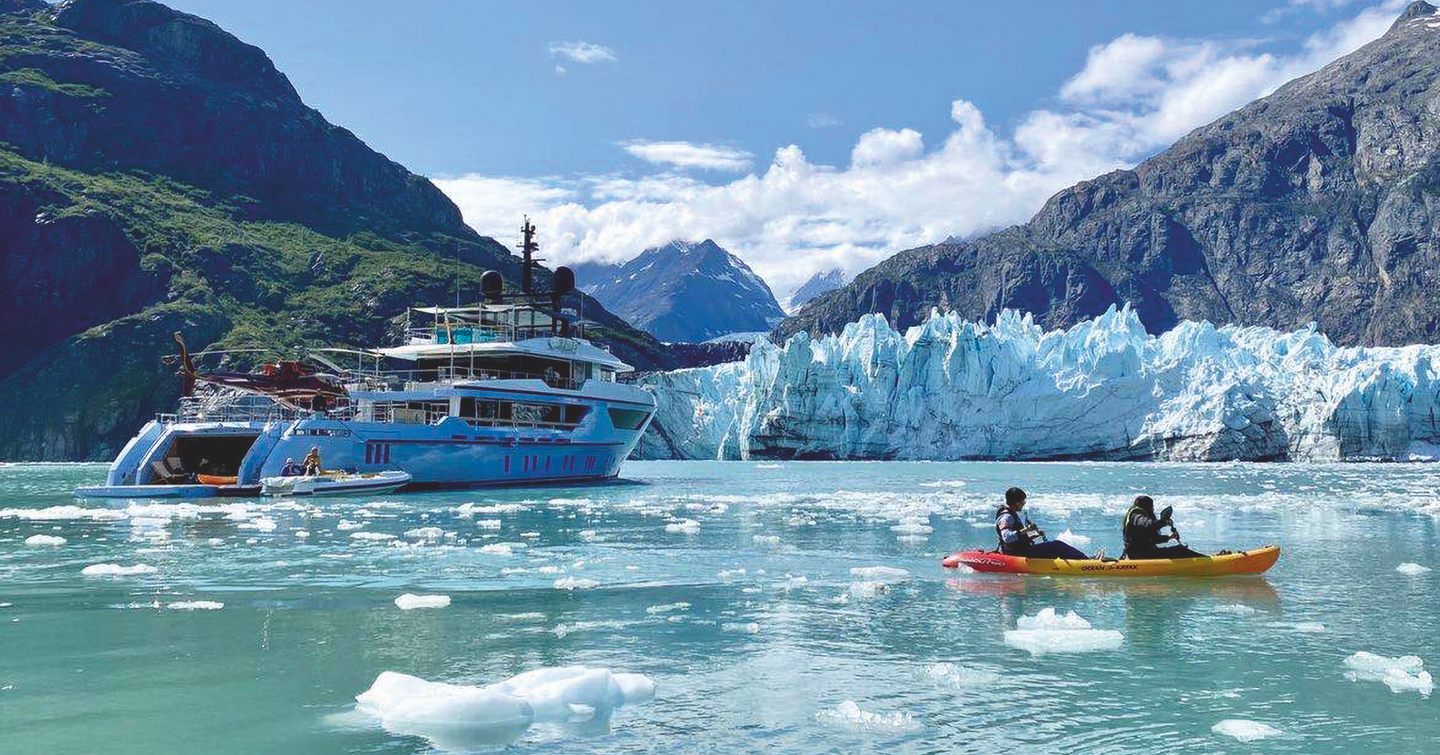 Ocean Dreamwalker III with guests in kayak in front and ice in background