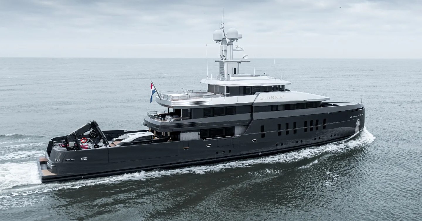 Overview of M/Y SHINKAI underway, surrounded by sea and a cloudy sky.