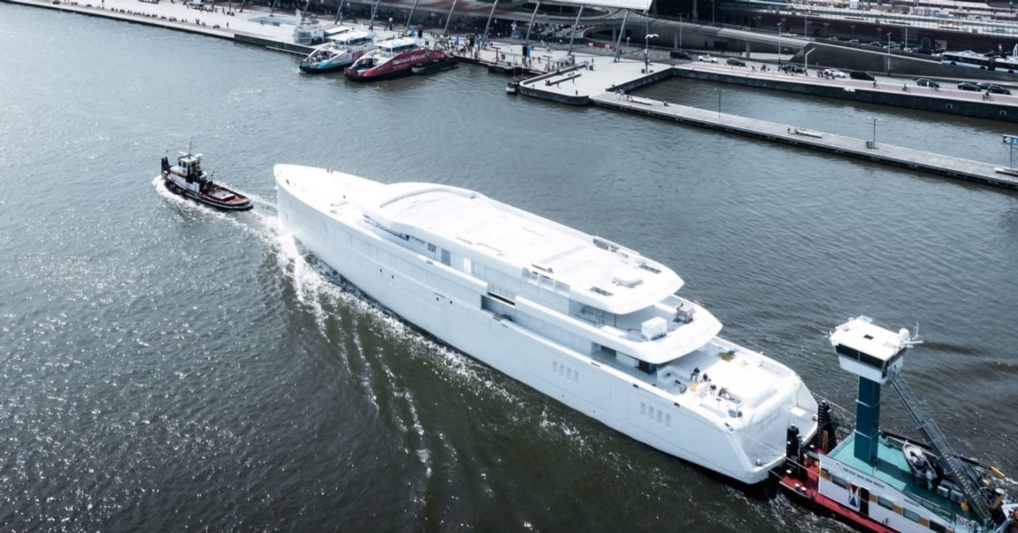 Aerial view of Superyacht Feadship 1015 following tugboat outside shipyard pre-outftting 