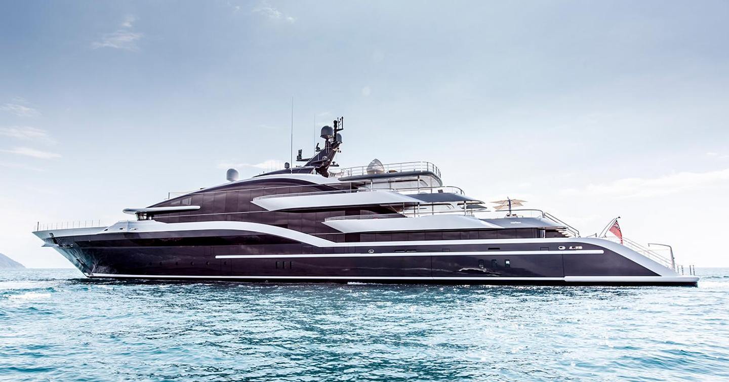 Oceanco yacht DAR shown from water level looking towards port side profile, yacht stationary in still waters on bright day