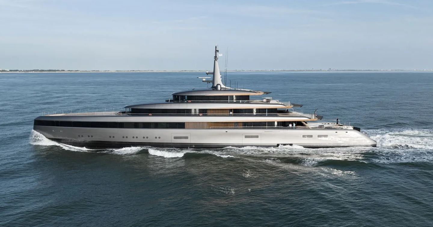 Feadship yacht OBSIDIAN shown mid aerial running shot towards port side profile, yacht moving at speed in calm waters on clear day