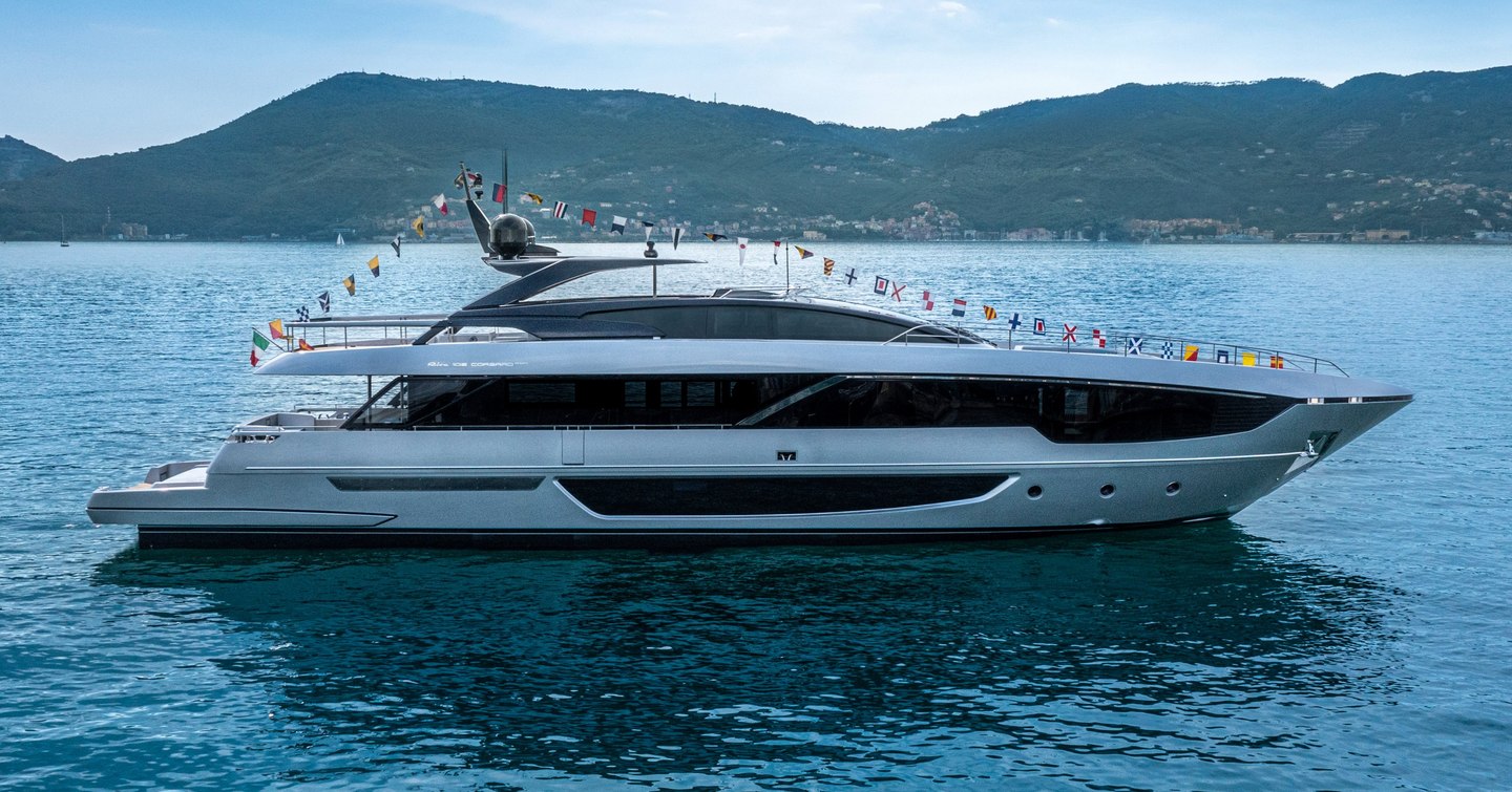 Riva 102 Corsaro Super underway, surrounded by sea and mountainous terrain in background.