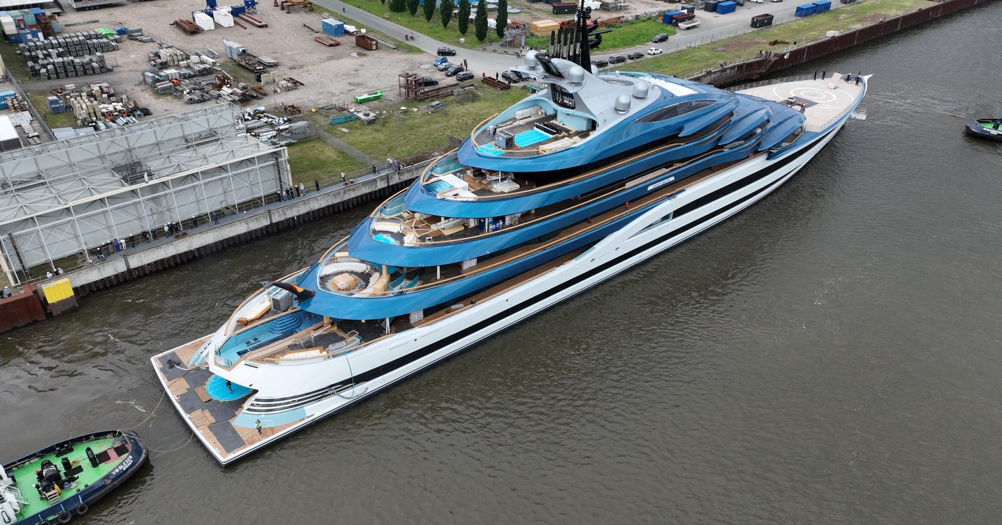 Superyacht Alnanha docked outside Lurssen shipyard with tugboat behing 