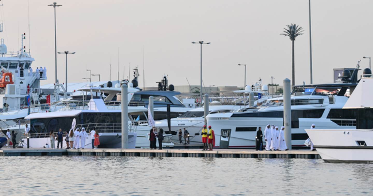 Motor yachts berthed at ADIBS with visitors along pontoon